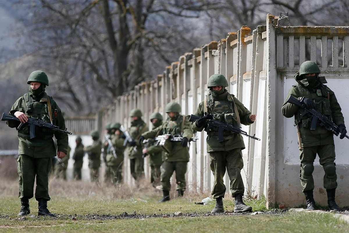 Armed men in military uniform surround the territory of a Ukrainian military unit in the village of Perevalnoye, outside Simferopol, 19 March 2014. Photo: EPA/YURI KOCHETKOV