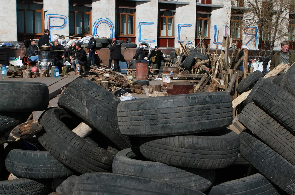 Пророссийские демонстранты отдыхают возле баррикады перед захваченным зданием областной администрации в Донецке, Украина, 8 апреля 2014 года. Фото: Photomig / EPA