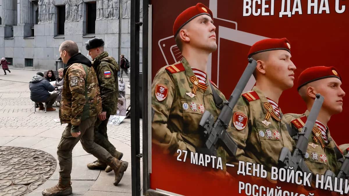 Russian servicemen walk past a billboard celebrating military service in St. Petersburg, Russia, 24 March 2026. Photo: EPA / ANATOLY MALTSEV