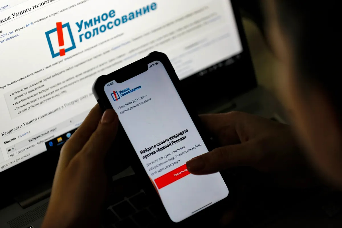 A woman examines Navalny’s Smart Voting app on her phone in Moscow, Russia, 17 September 2021. Photo: EPA-EFE / SERGEI ILNITSKY
