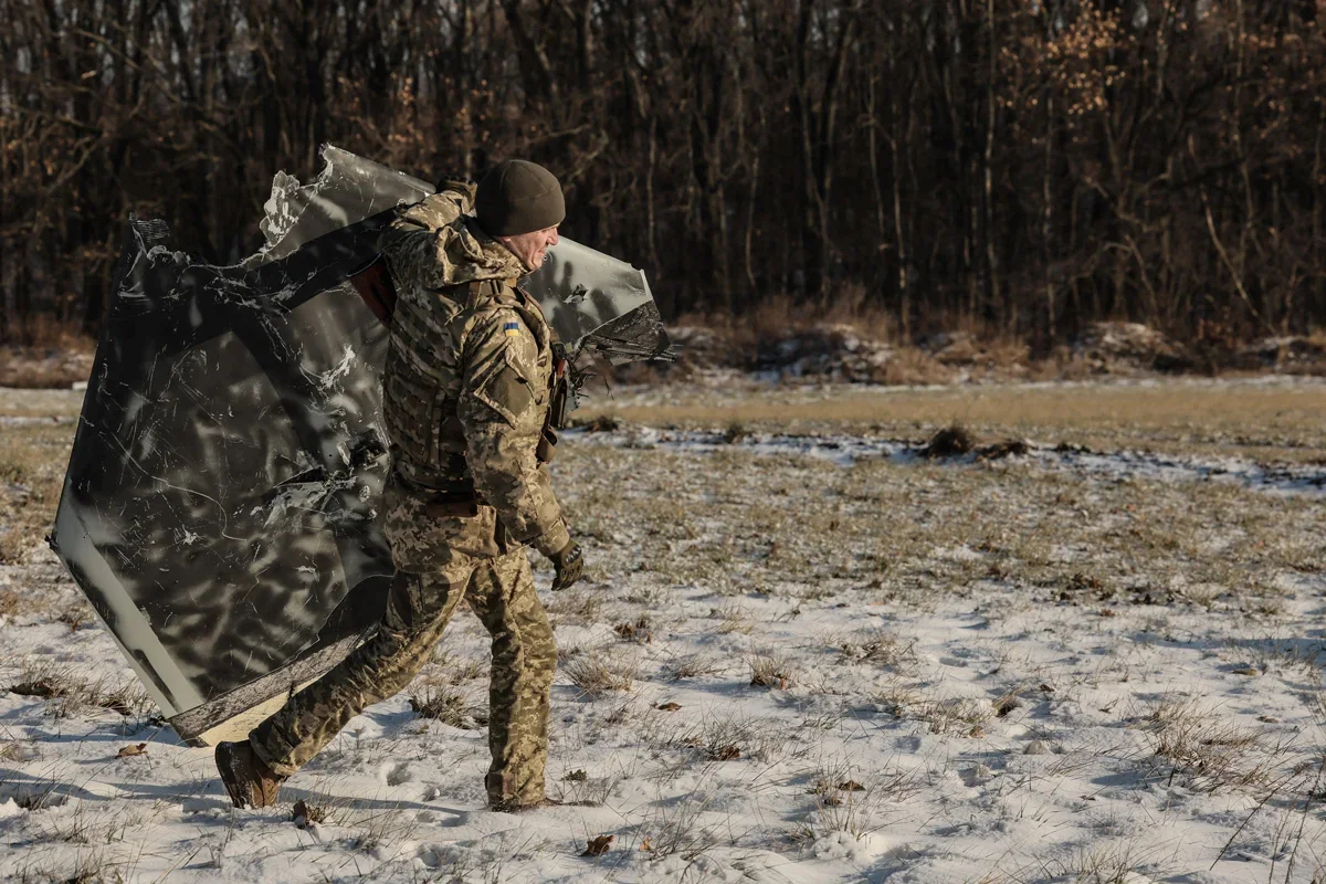 A Ukrainian soldier carrying the debris of a Shahed drone near Kyiv. Photo: Oleg Petrasiuk / EPA-EFE