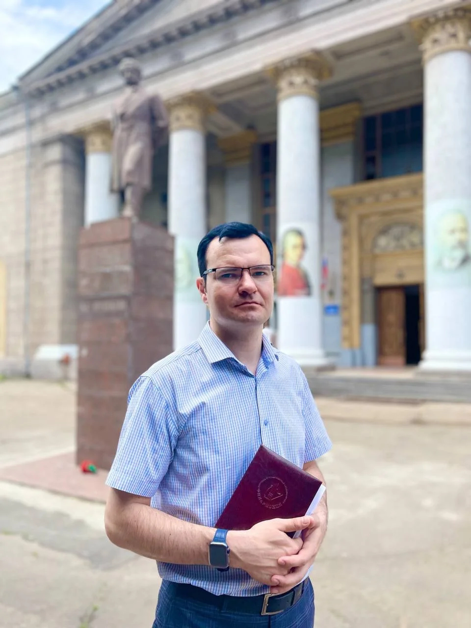 Александр Парецкий на фоне мариупольской филармонии 28 июня. В момент съемки Парецкий смотрит на сгоревший дом на проспекте Металлургов, где пыталась закрепиться группа Матвея. Фото: <a href="https://vk.com/wall-14343310_28390?z=photo-14343310_457268934%2F39c185cc04abdf66c6">ВКонтакте</a><br>