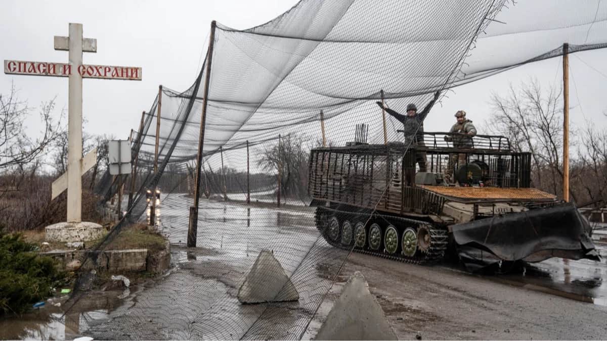Украинские военные на бронетехнике движутся по дороге, закрытой специальными сетками для защиты от беспилотников, недалеко от прифронтовой Дружковки, Донецкая область, Украина, 14 февраля 2026 года. Фото: Tommaso Fumagalli / EPA