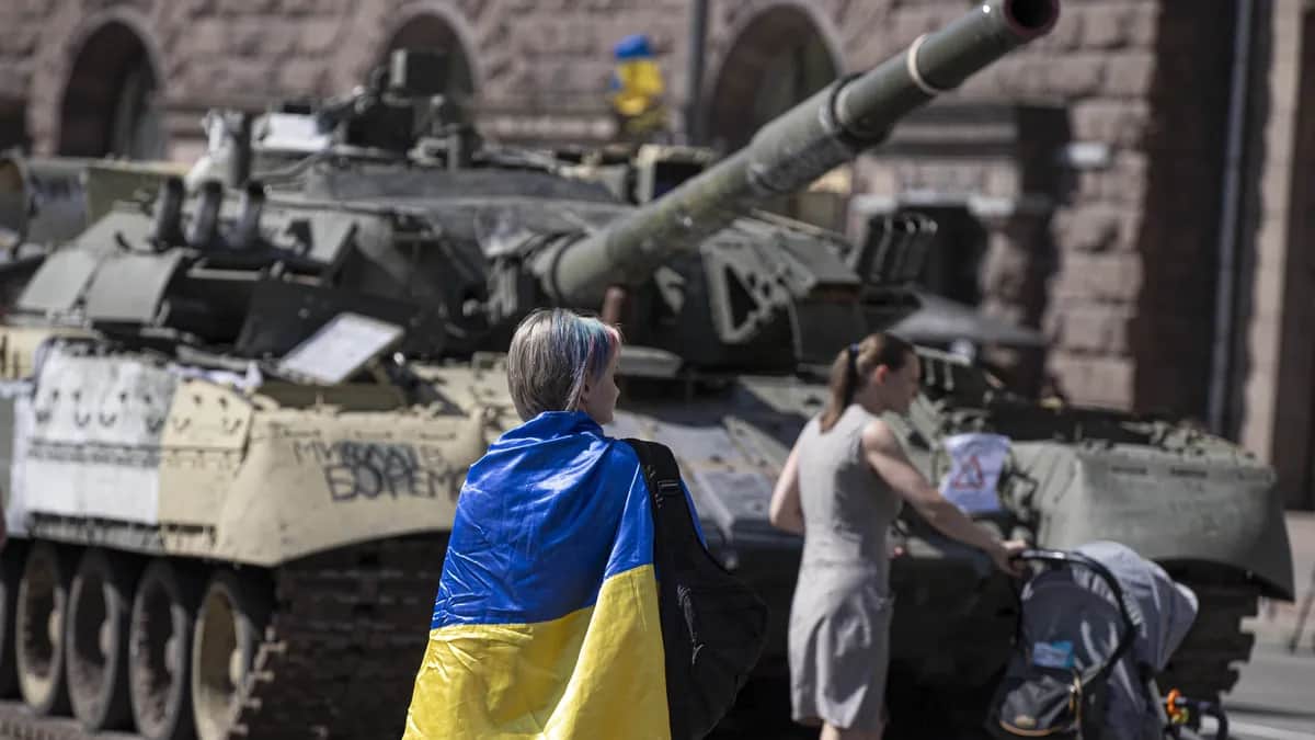 Украинка перед танком, захваченным украинскими войсками. Киев, 24 августа 2022 г. Фото: Metin Aktas/Anadolu Agency via Getty Images
