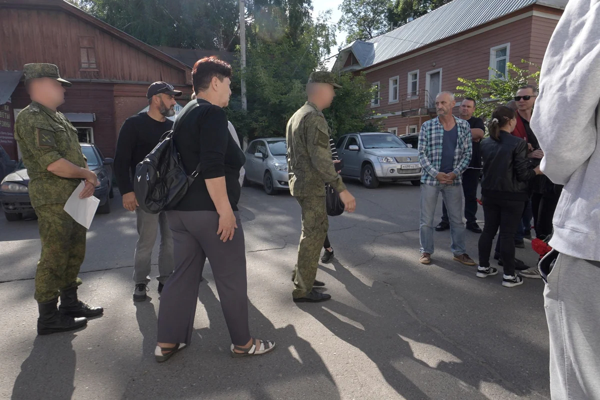 Собравшиеся около морга общаются с людьми в военной форме. Фото: «Ветер»