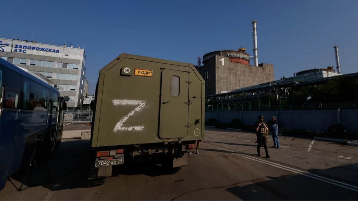 <span>Машина российских военных на фоне Запорожской атомной электростанции в Энергодаре, Украина, 15 июня 2023 года. Фото: Сергей Ильницкий / EPA</span>