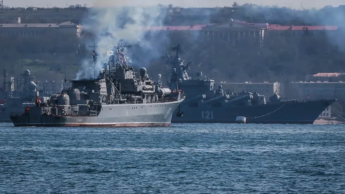 Российский патрульный корабль швартуется перед ракетным крейсером «Москва» в бухте Севастополя, 30 марта 2014 года. Фото: Сергей Ильницкий / EPA-EFE