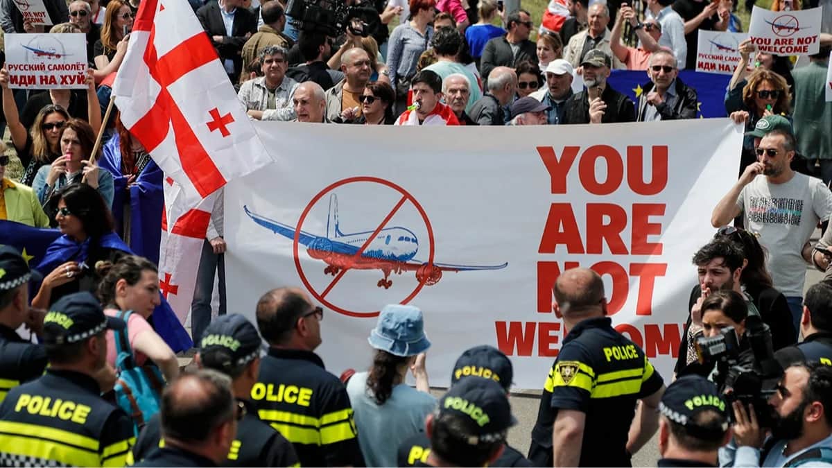 Люди протестуют против возобновления авиасообщения с Россией во время прибытия первого прямого рейса российской авиакомпании «Азимут» из Москвы в Тбилисский международный аэропорт в Тбилиси, Грузия, 19 мая 2023 года. Фото: Zurab Kurtsikidze / EPA
