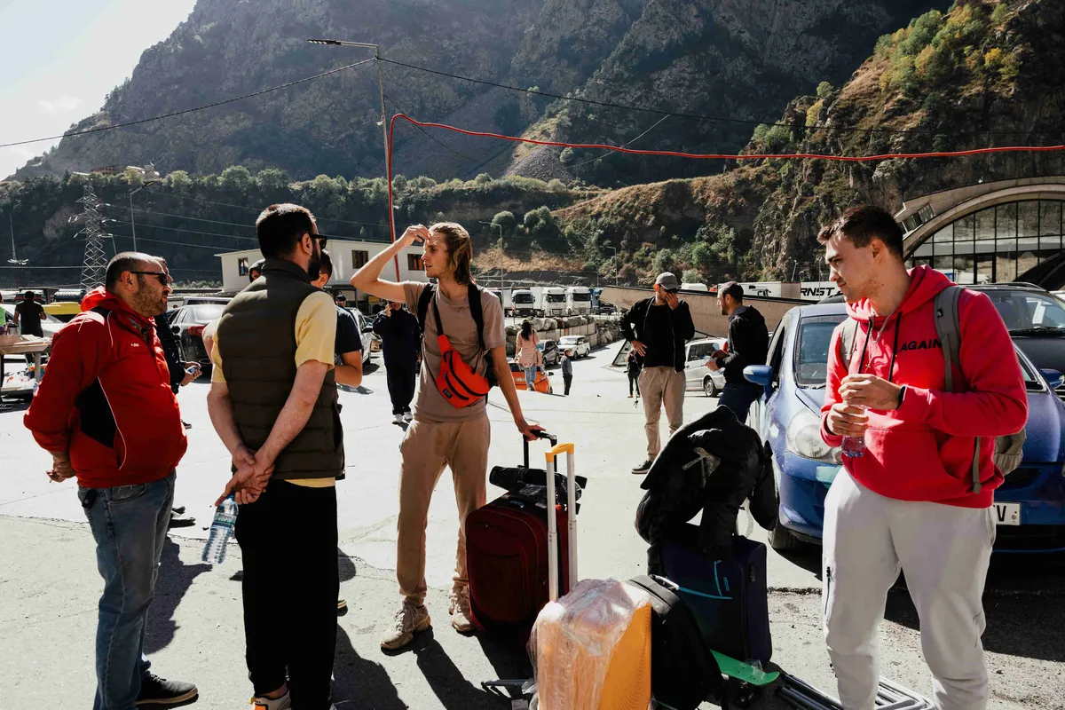 People arriving from Russia through the Verkhny Lars border crossing wait for a taxi for onward travel in Dariali, Georgia, on Friday, Sept. 30, 2022. Photo: Tako Robakidze / Bloomberg / Getty Images