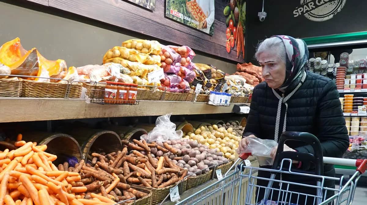 Пожилая женщина покупает продукты в SPAR. Фото: Максим Шипенков / EPA-EFE