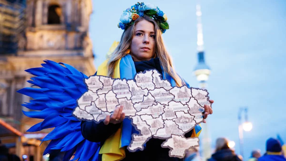 A protester poses with a stylised map of Ukraine during a rally in Berlin, Germany, 24 February 2025. Photo: EPA/CLEMENS BILAN