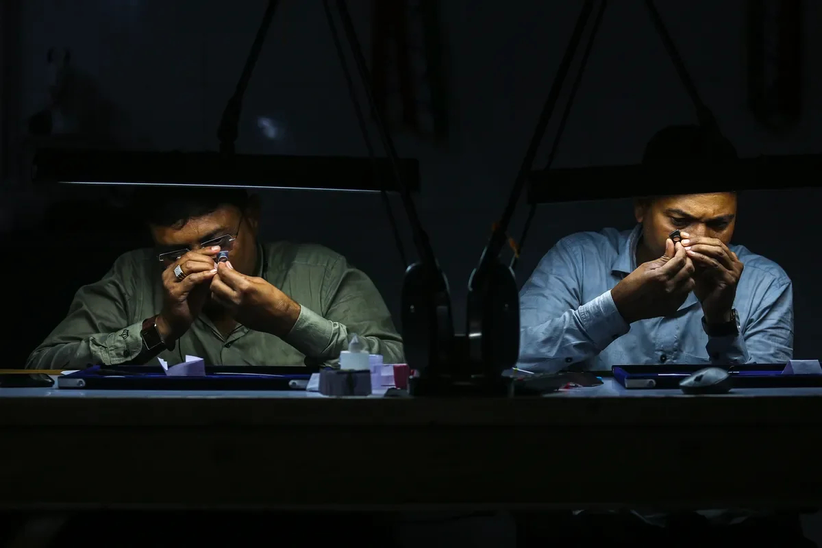 Employees inspect diamonds at a diamond workshop in India, where 80% of the world's diamonds are cut and polished. Photo: Divyankani Solanki / EPA-EFE