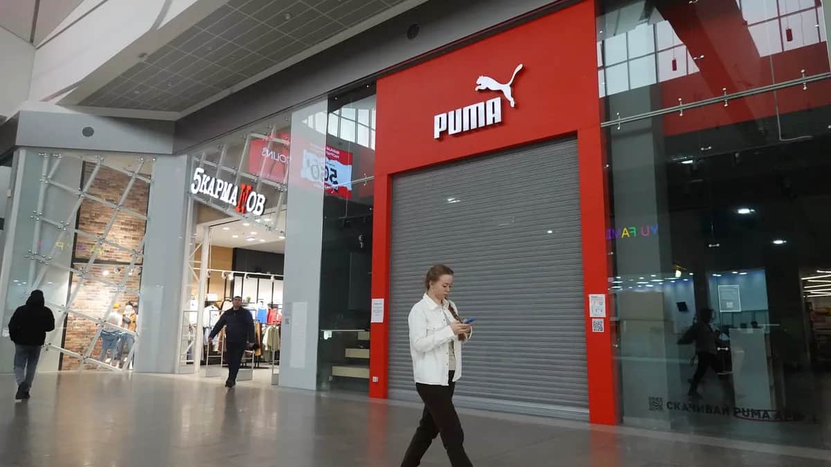 Покупатели идут перед закрытым магазином Puma в торговом центре «Мега» в Москве. Фото: Максим Шипенков / EPA-EFE