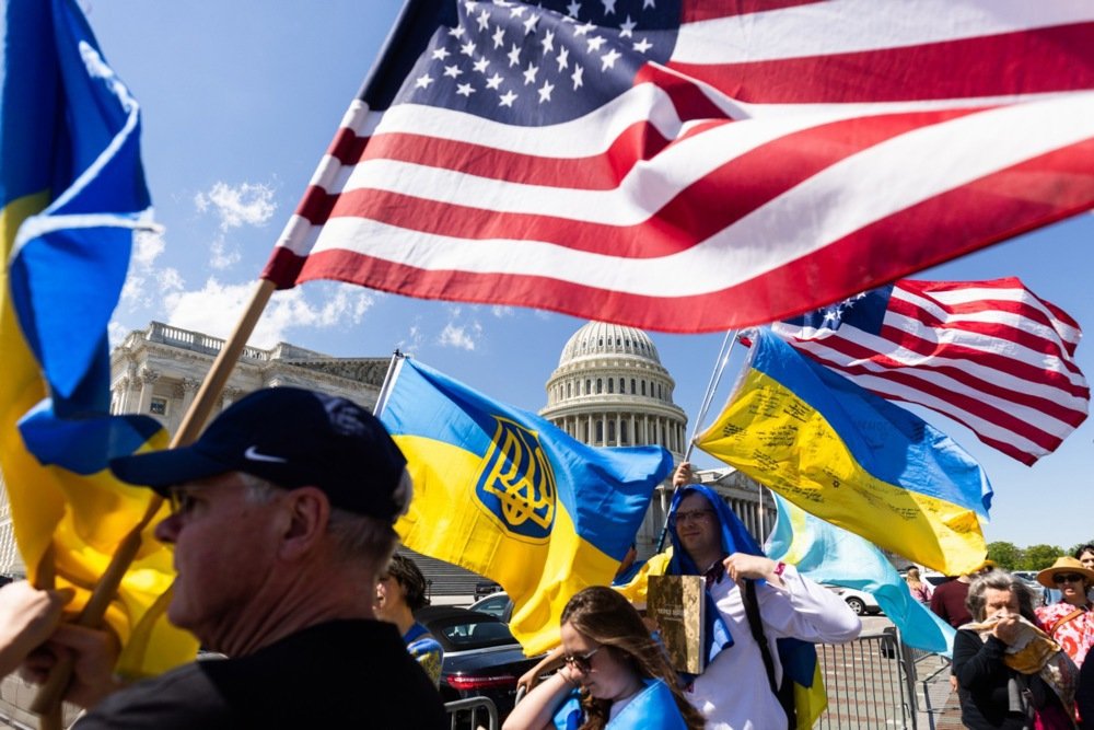 Supporters of Ukraine wave US and Ukrainian flags outside the US Capitol as the House of Representatives passed the Ukraine aid bill on 20 April 2024. Photo: EPA-EFE/JIM LO SCALZO