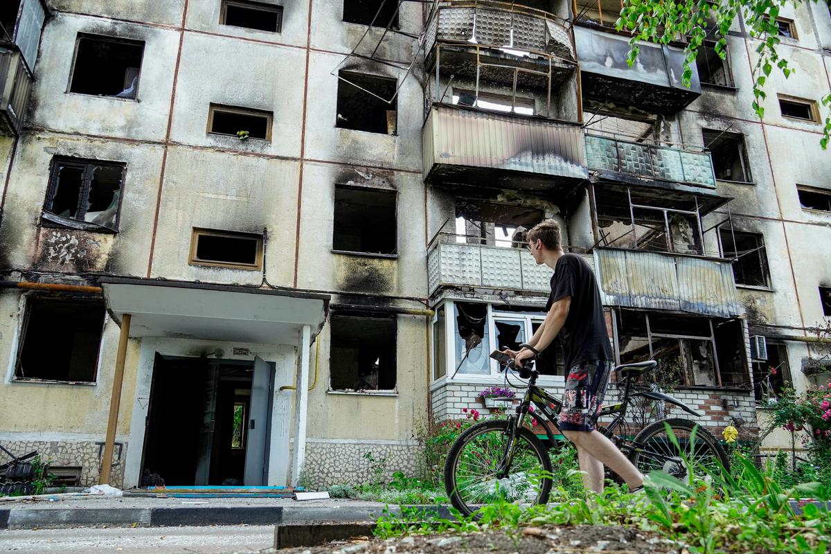 A resident looks at a burnt-out building in the Belgorod region town of Shebekino, in southwestern Russia, 2 July 2023. Photo: EPA